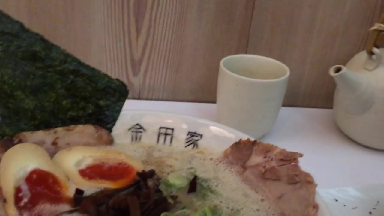 Pork slices, soft-boiled egg and nori in a bowl of tonkotsu ramen