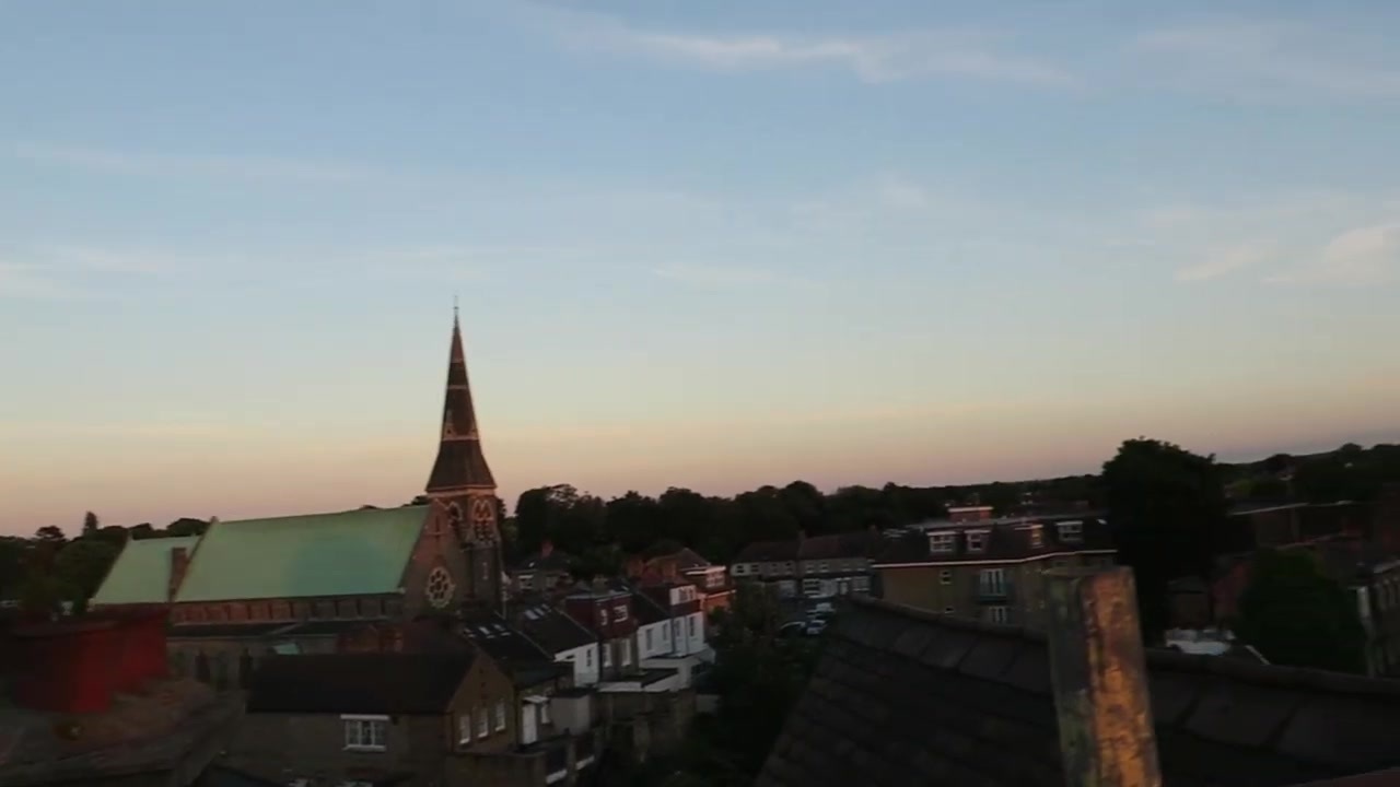 A church spire and neighbouring rooftops in the evening light.