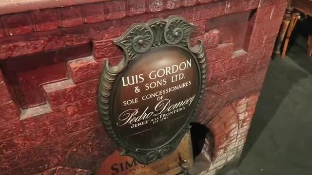 A decorative Luis Gordon & Sons plaque against the cellar brickwork.