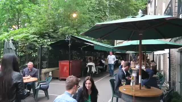 Green umbrellas over the outdoor tables beside Embankment Gardens.