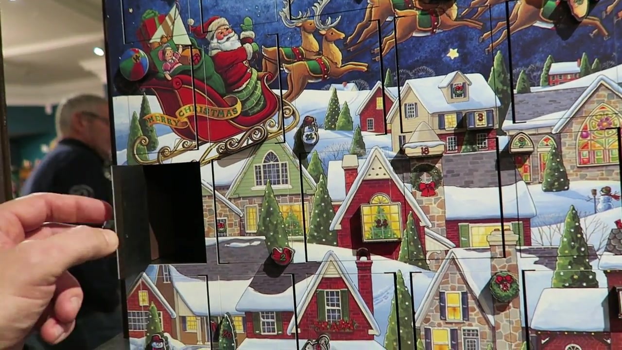 Illustrated chocolate Advent calendar held towards the camera
