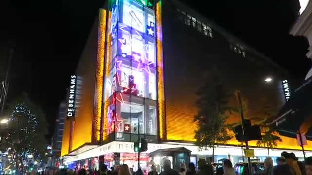 Debenhams Oxford Street lit in warm colours at night in 2015
