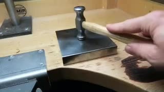 Hammer and steel block used while setting back silver cufflink fronts