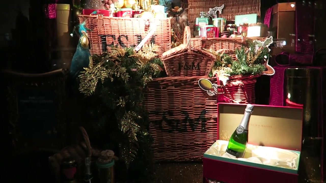 Wicker hamper and gift boxes in a richly decorated Christmas window