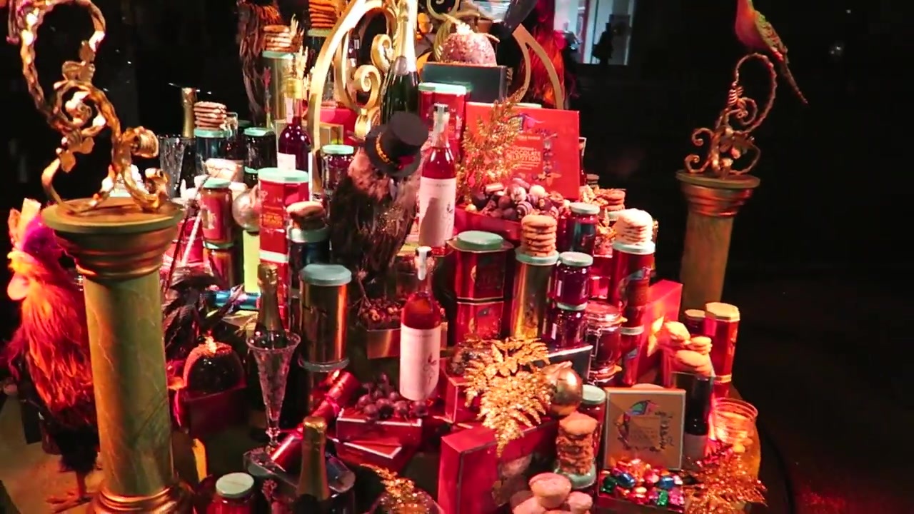Red and gold Christmas window display filled with gifts and decorative objects