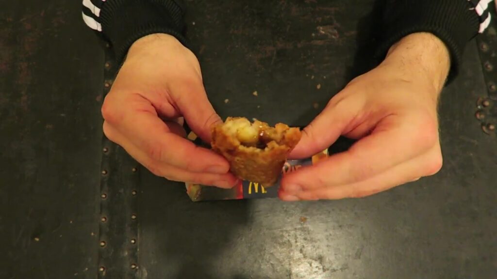Hands holding an opened McDonald’s Festive Pie to show the filling