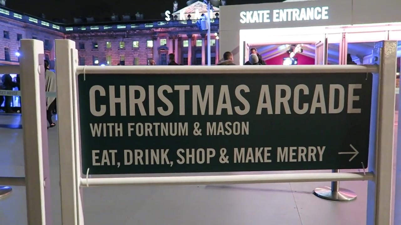 A sign for the Christmas Arcade with Fortnum & Mason beside the Somerset House ice rink.