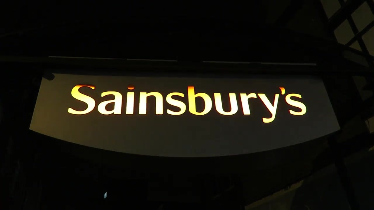 Illuminated Sainsbury’s sign outside the supermarket at night