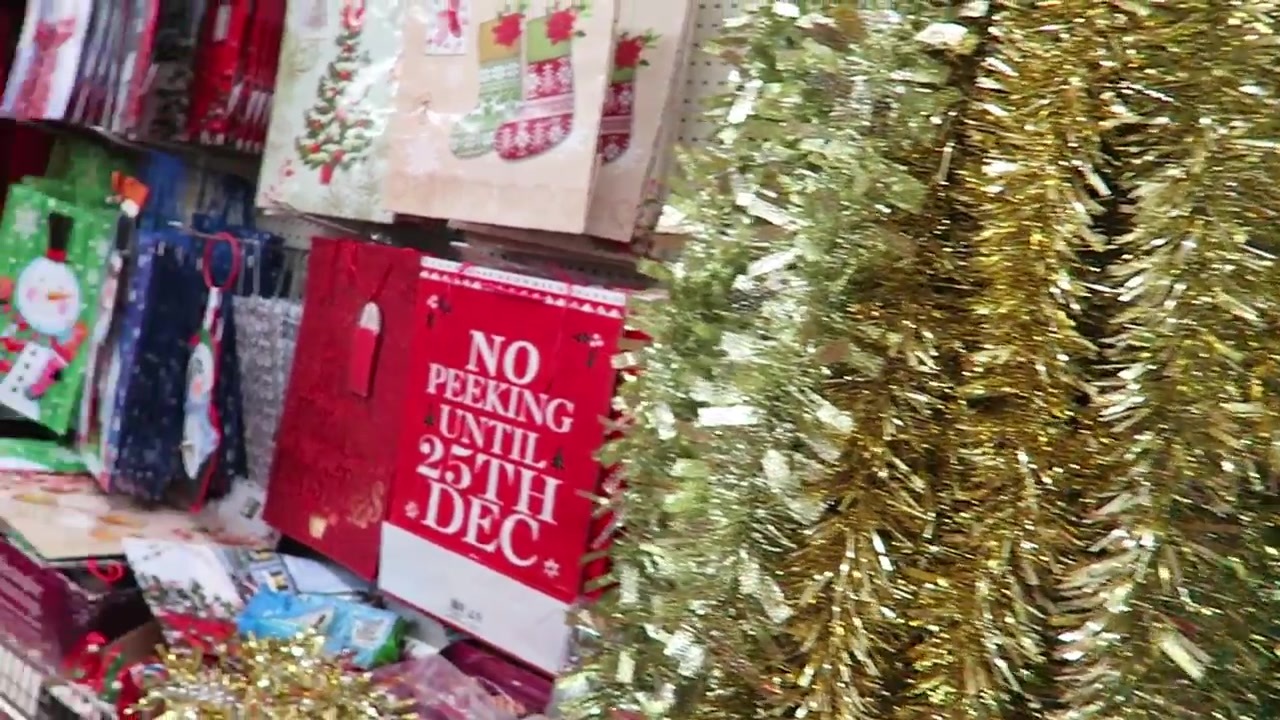 Gold tinsel hanging beside Christmas stockings in a shop