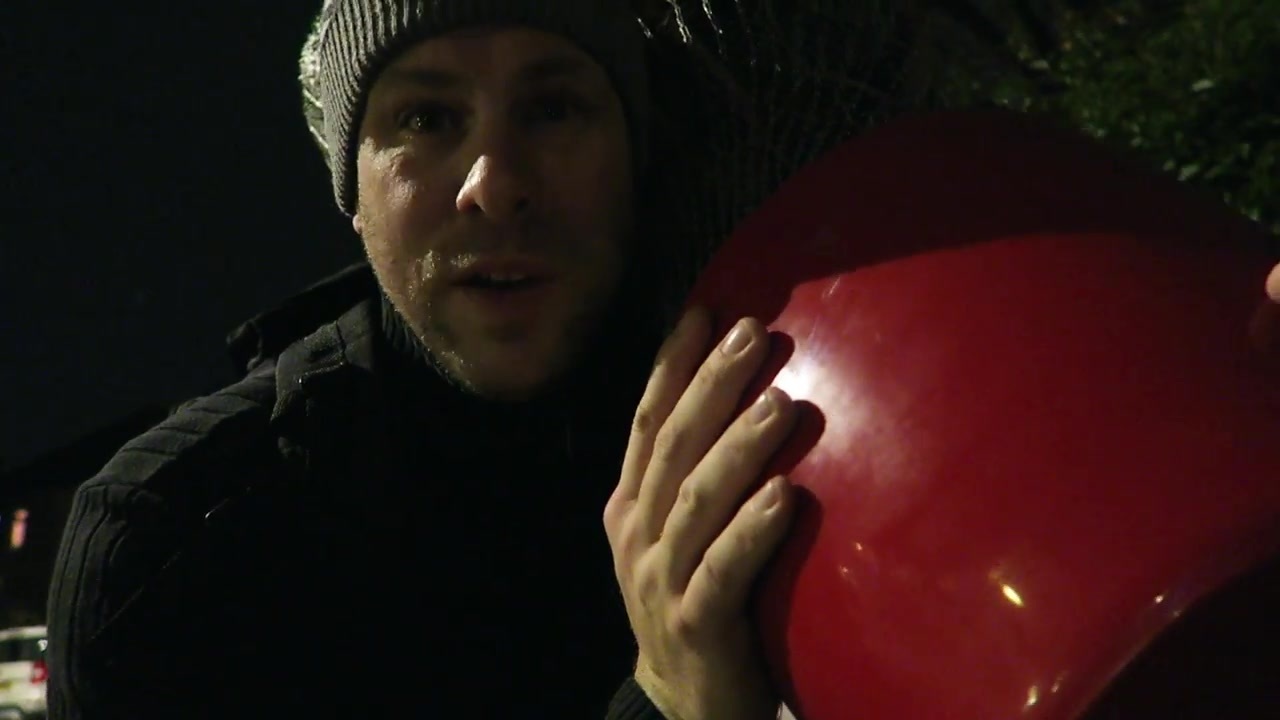 Barry carries the Christmas tree in its red pot home at night.
