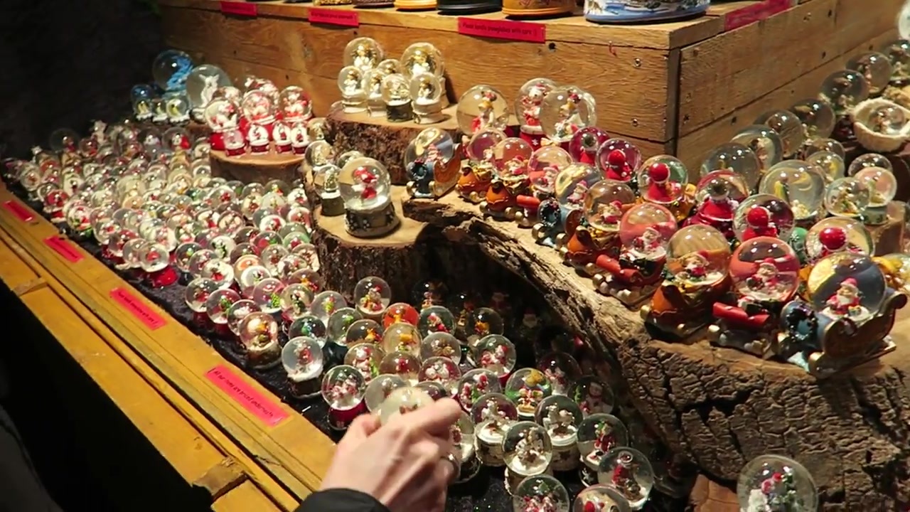 Rows of small Christmas snow globes on a market stall