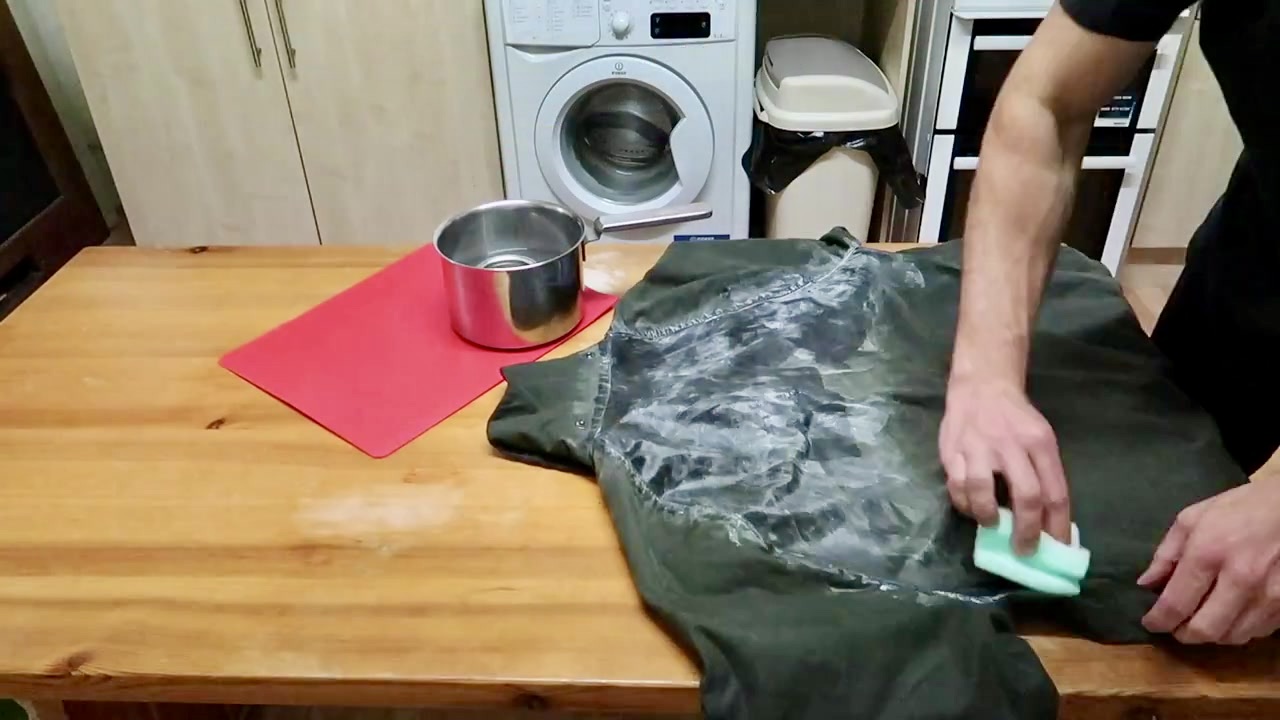 Wax dressing being worked into a Barbour wax jacket with a sponge