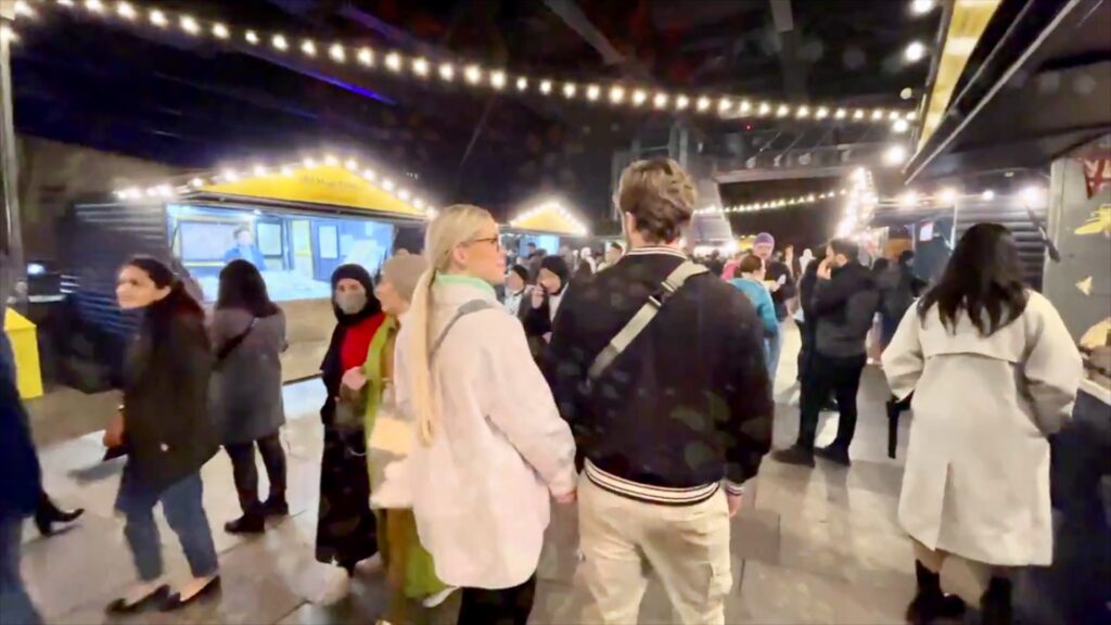 South Bank winter market with illuminated stalls and crowds beside the Thames