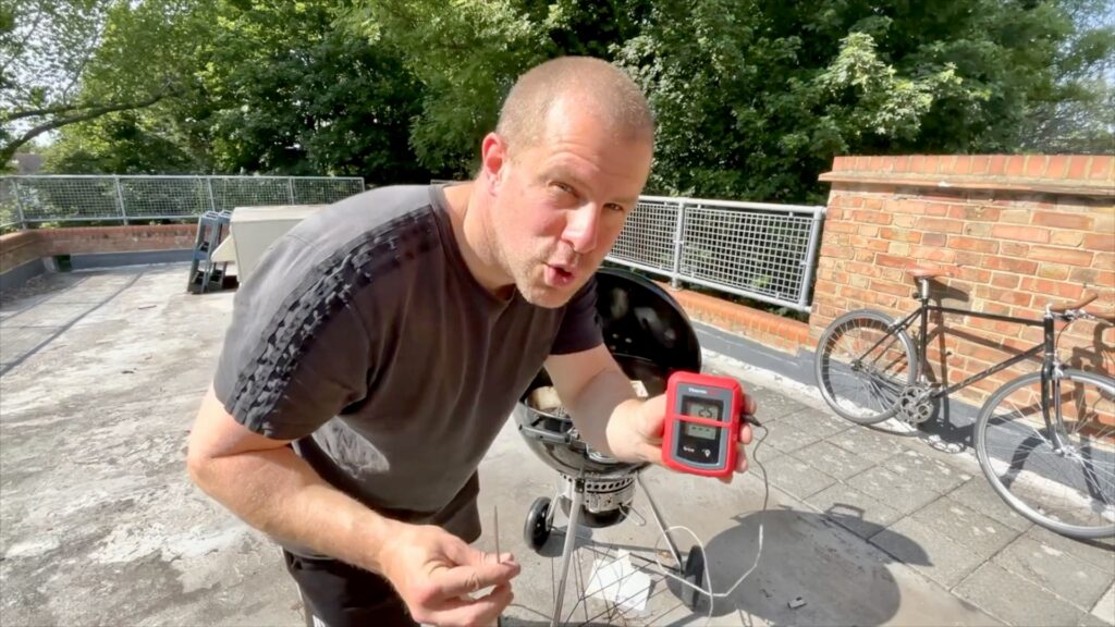 ThermoPro digital meat thermometer used to monitor food on a charcoal barbecue
