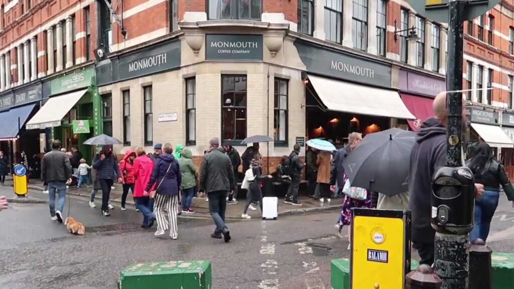 Monmouth Coffee shop and customer queue at Borough Market on a rainy London day