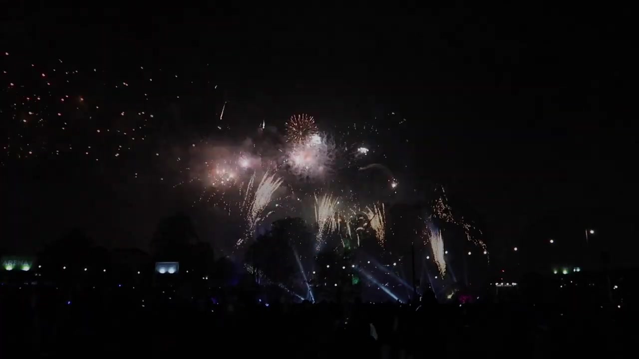 White fireworks and blue light filling the night sky above Victoria Park