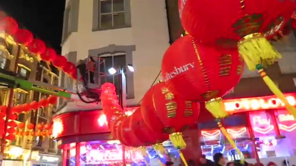 Red Chinese New Year lanterns above a busy street in London’s Chinatown