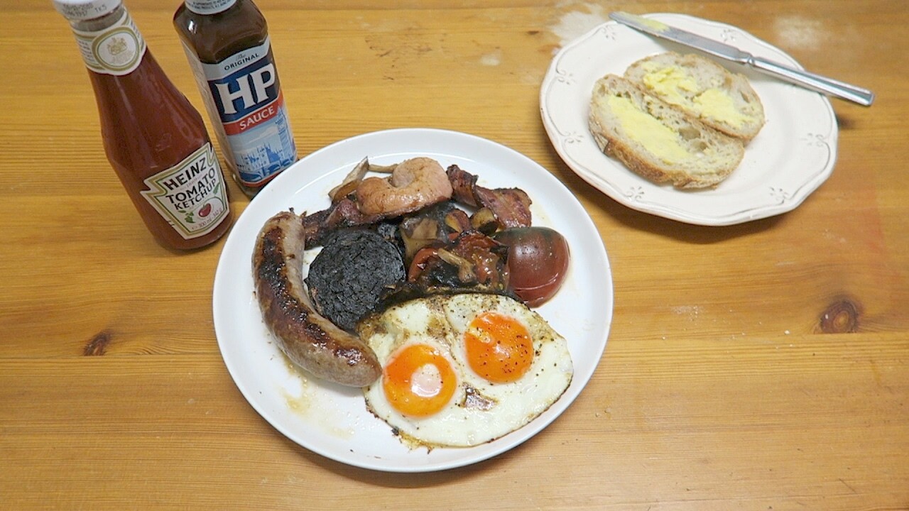 Full English breakfast with sausage, bacon, black pudding, fried eggs, mushrooms, tomato and sourdough toast.