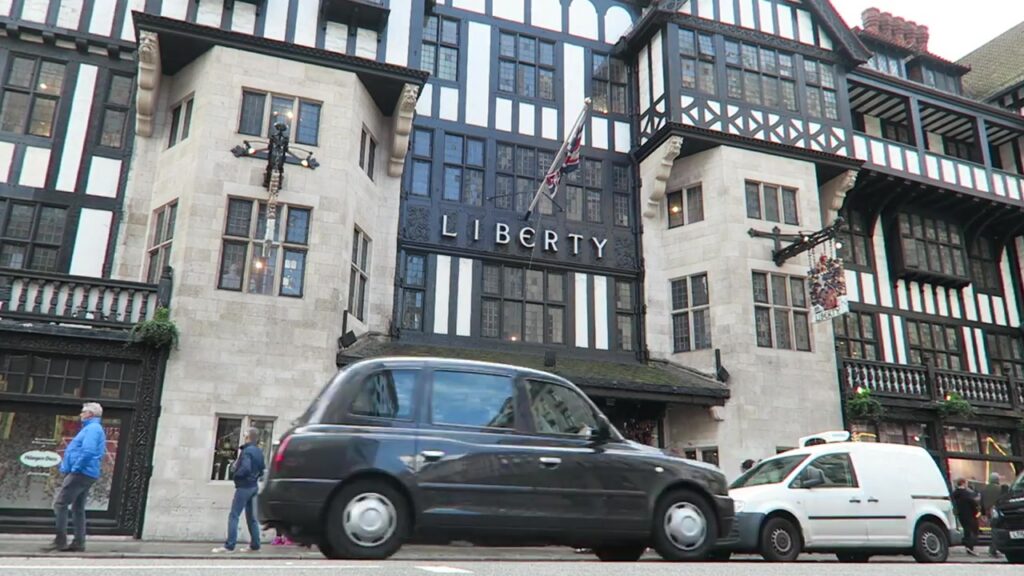 Liberty London's Tudor-revival façade with a black taxi passing outside