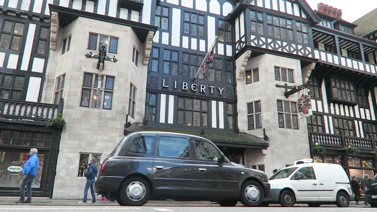 Liberty London's Tudor-revival façade with a black taxi passing outside