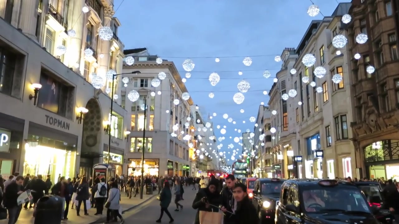 White globe Christmas lights suspended above shoppers and traffic on Oxford Street in 2014.