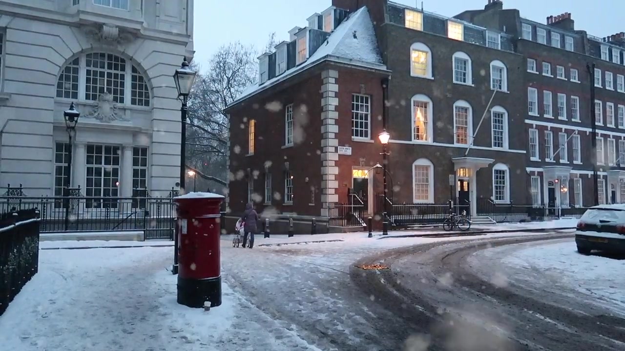Snow-covered central London street with a red postbox in March 2018