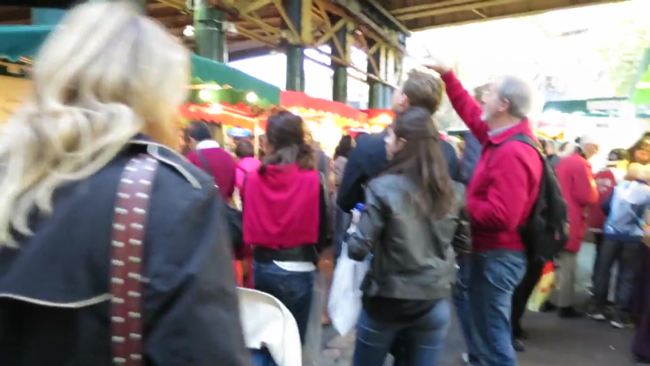 Busy covered aisle inside Borough Market during a Saturday food tour