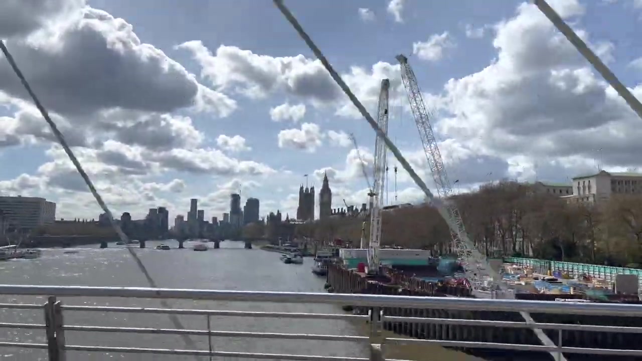 London Eye and Palace of Westminster seen across the Thames from the Golden Jubilee Bridges.