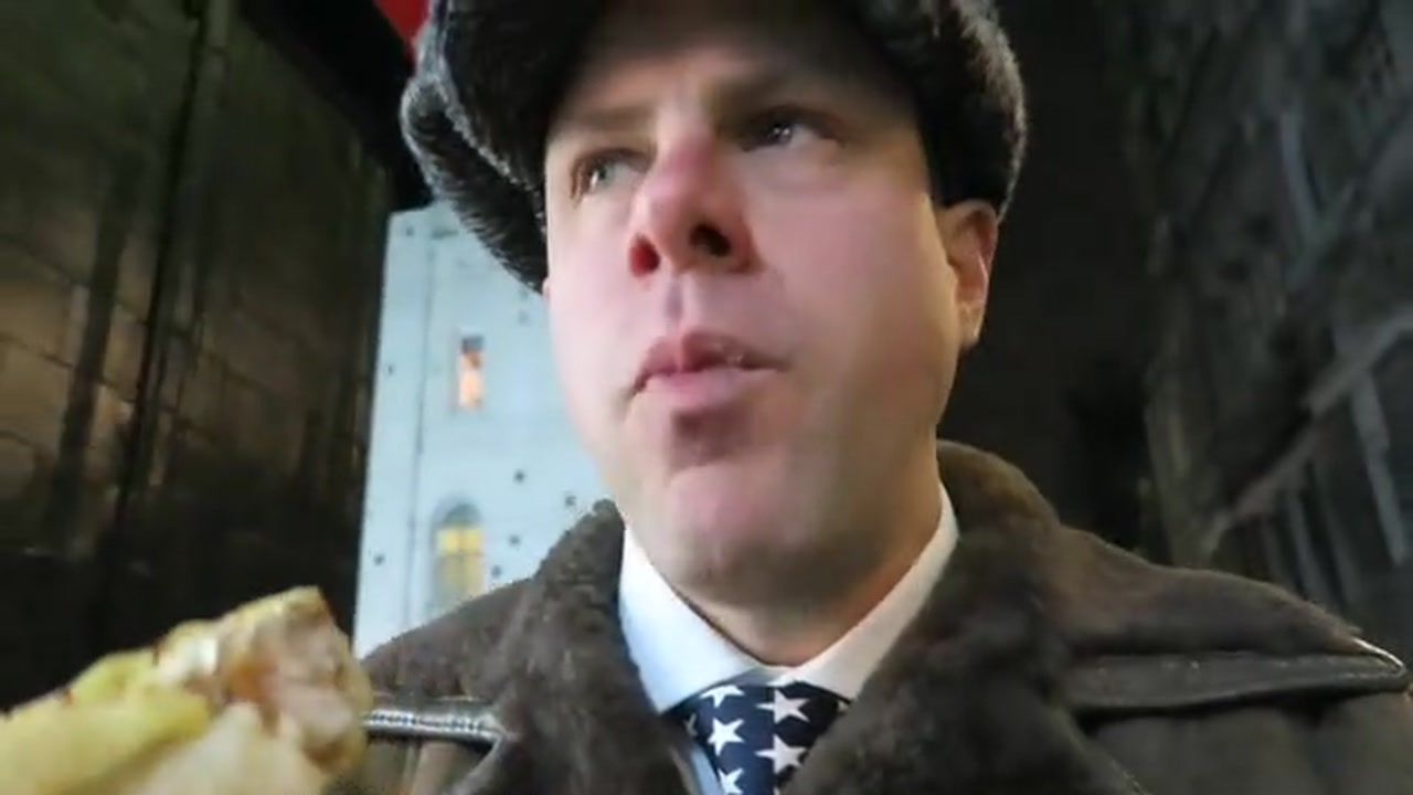 Barry Roberts eating a German sausage during the walk to Oxford Street
