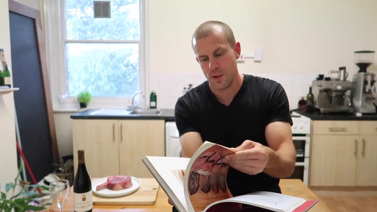 Barry Roberts holding a Hawksmoor cookbook while discussing steak at home