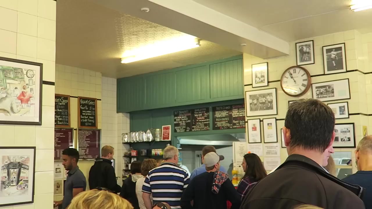 Customers queuing beneath blackboard menus inside the Regency Café in 2016.