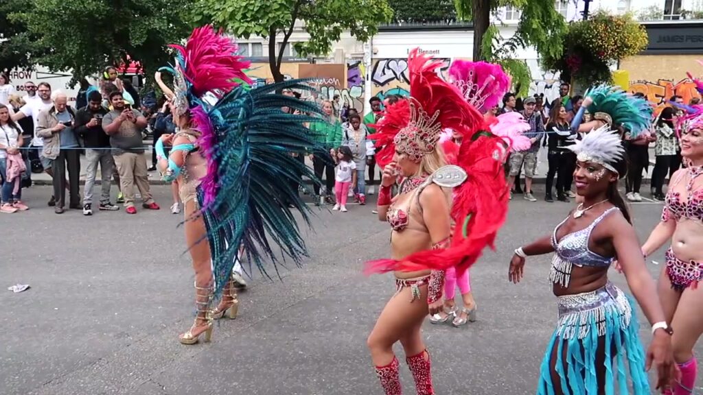 Masquerade performers wearing colourful feathered costumes at Notting Hill Carnival 2018