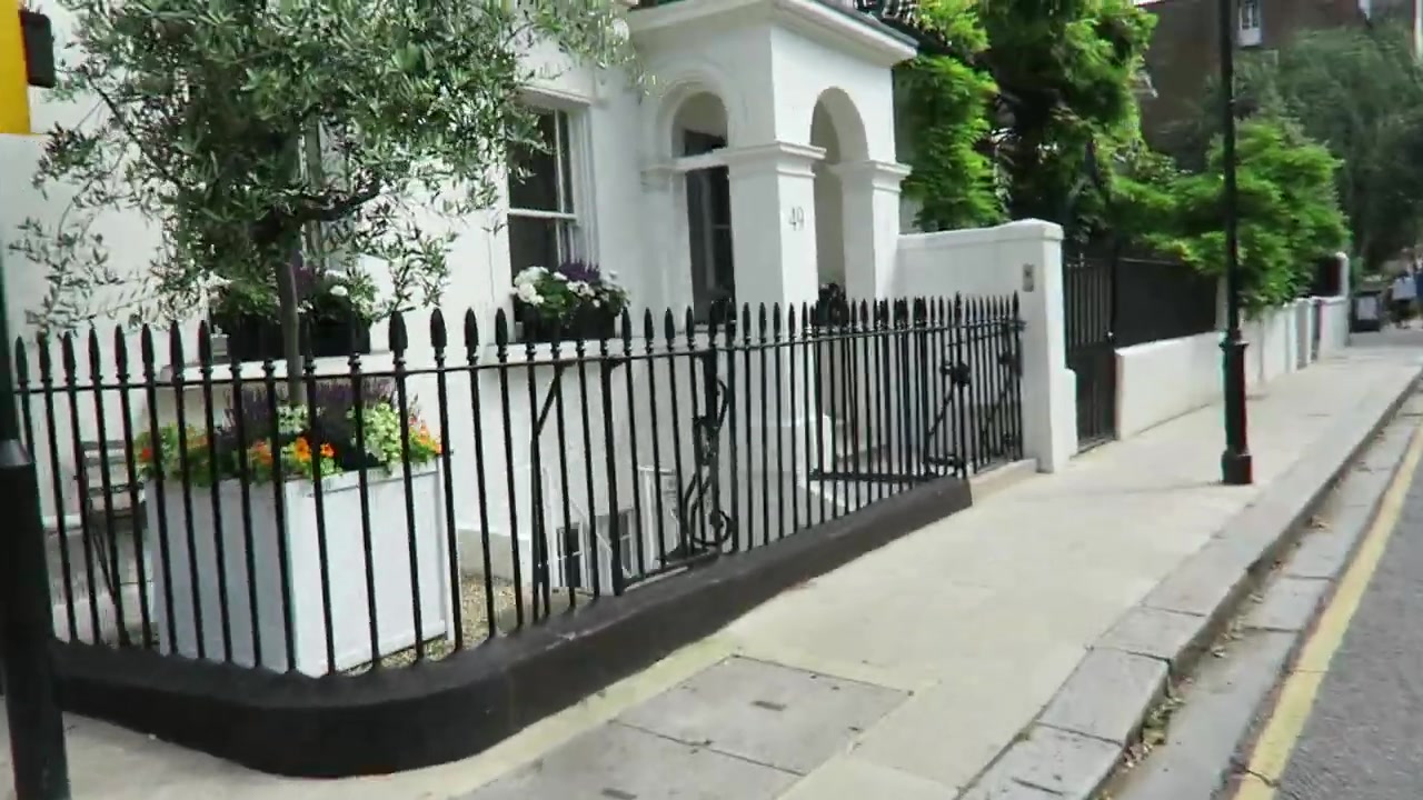 White Chelsea townhouse with arched porch and black iron railings