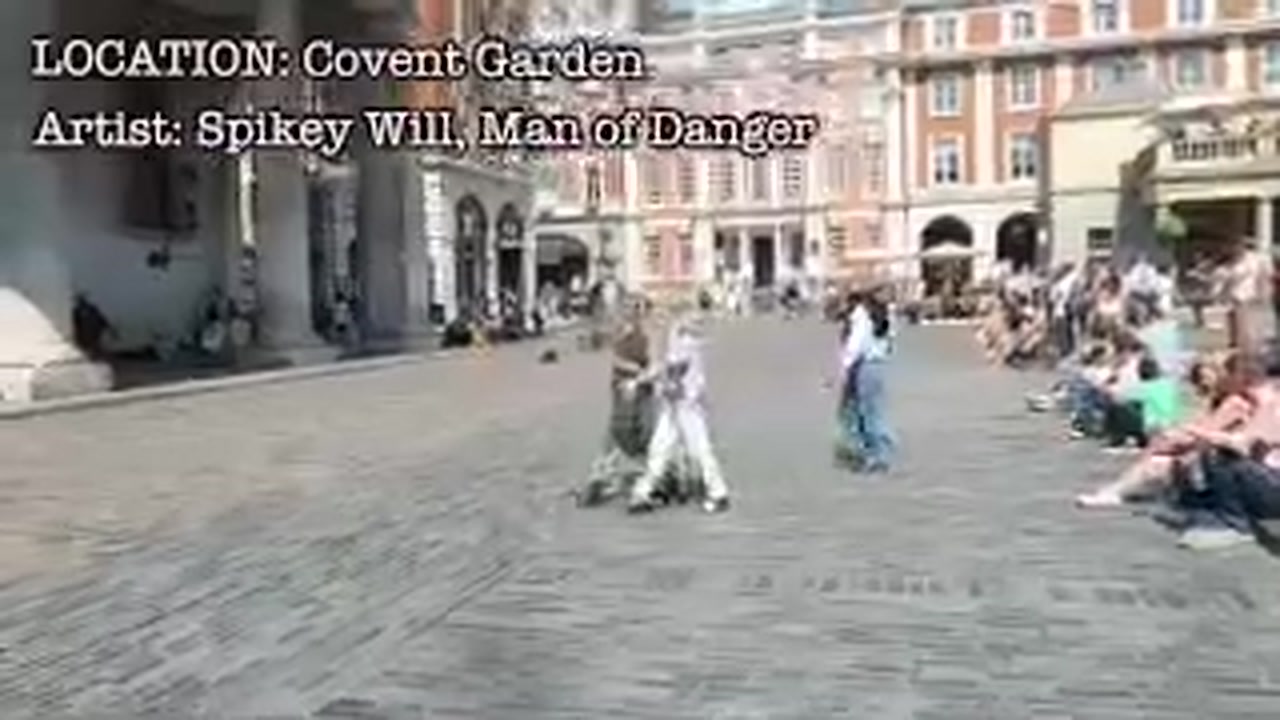 Street performer Spikey Will entertaining a seated crowd in Covent Garden.