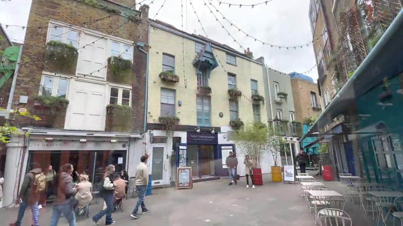 Neal’s Yard courtyard in Seven Dials with colourful painted façades, trees and outdoor tables.