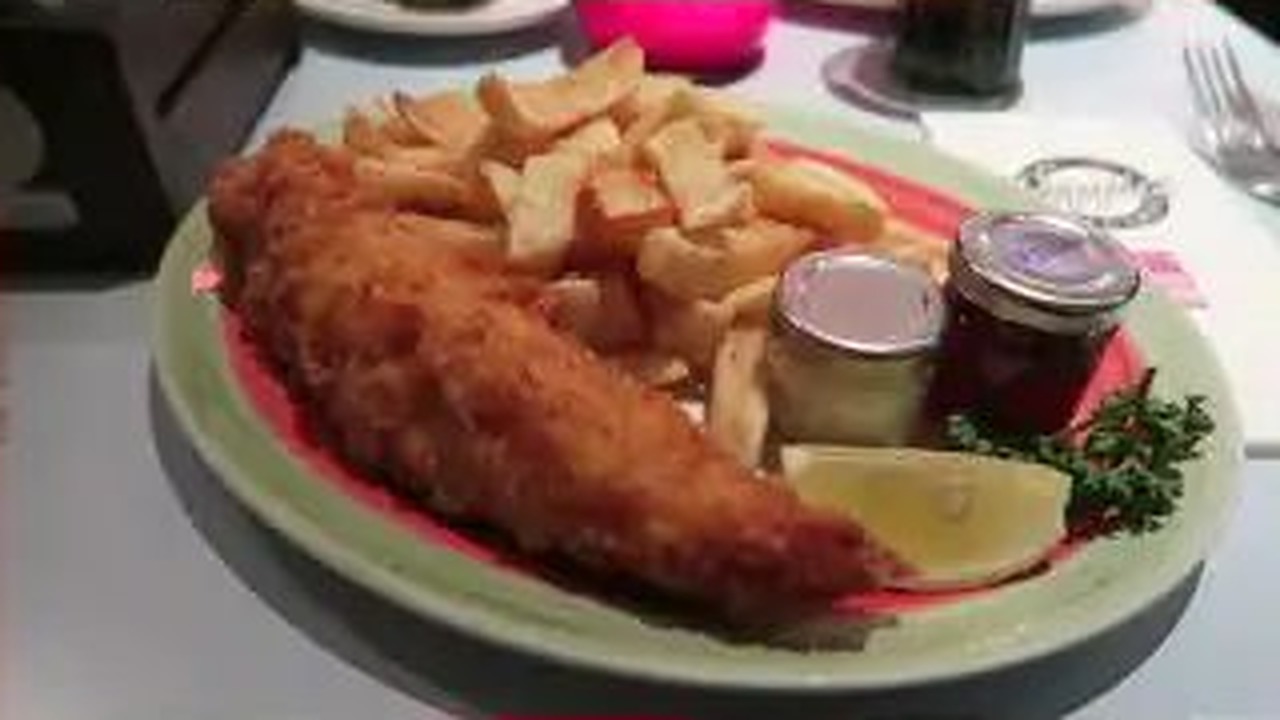 Cod and chips served with lemon, tartare sauce and ketchup at Poppies Spitalfields in January 2016.