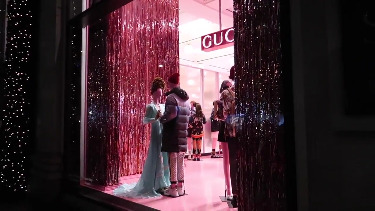 A theatrical Selfridges Christmas window glowing pink on Oxford Street in 2018