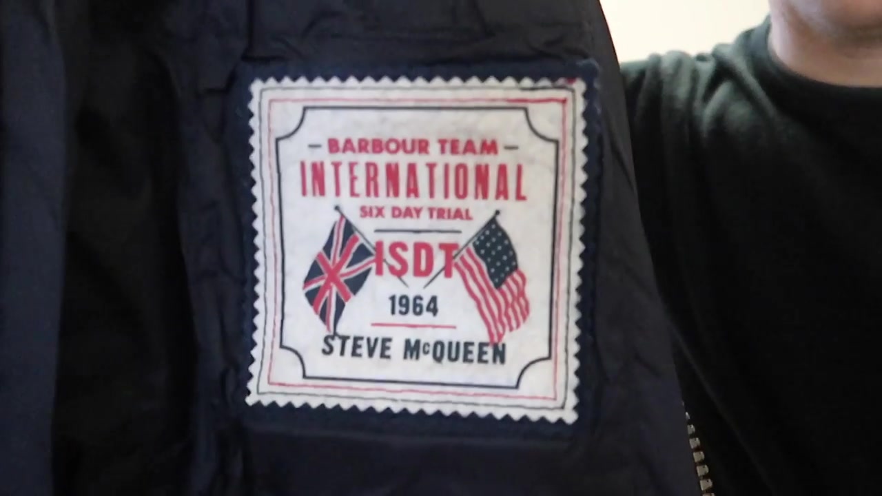 Embroidered Barbour International Steve McQueen patch on the sleeve of a navy quilted jacket.