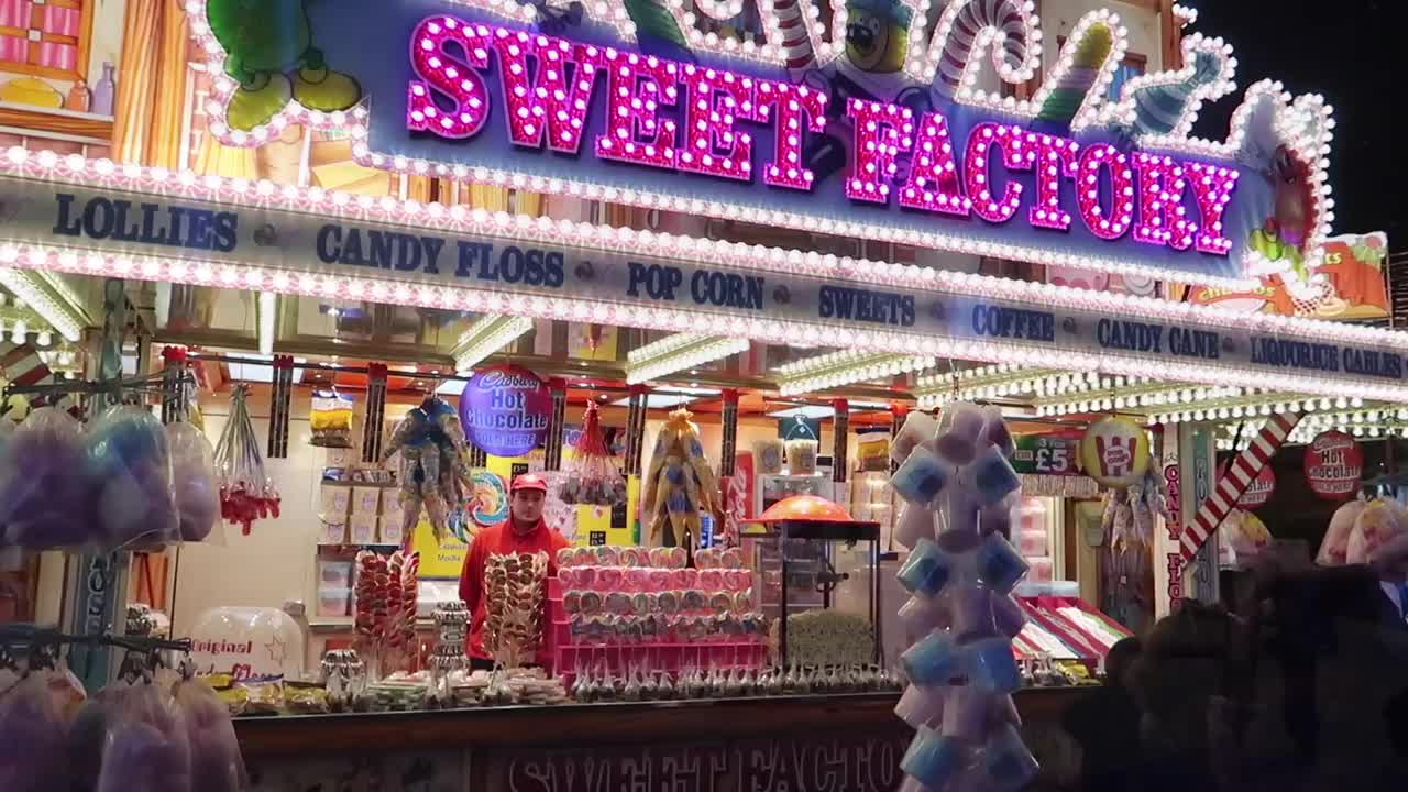Brightly illuminated sweet stall selling candy floss and confectionery at Winter Wonderland 2017