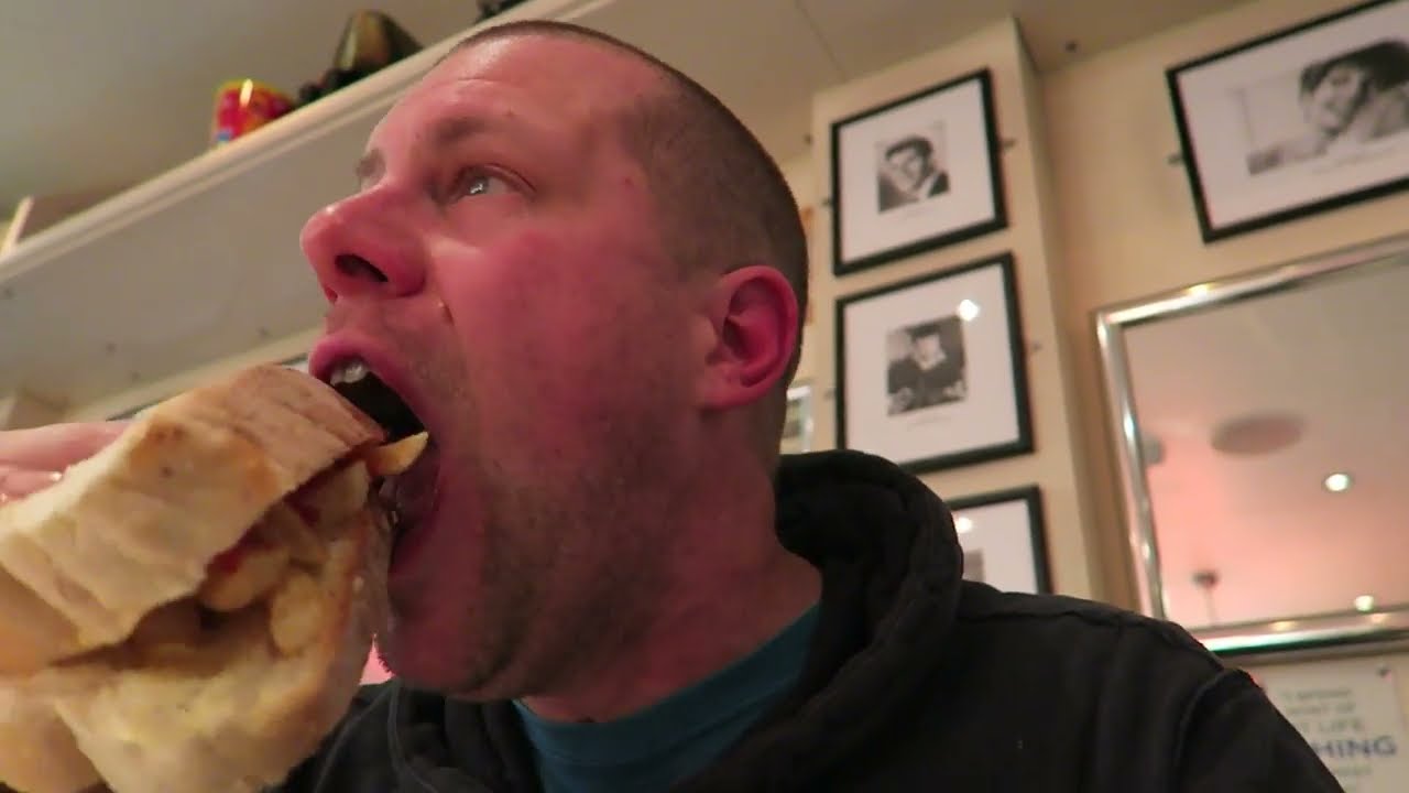Barry Roberts eating a chip butty made with bread and chips at Poppies Spitalfields.