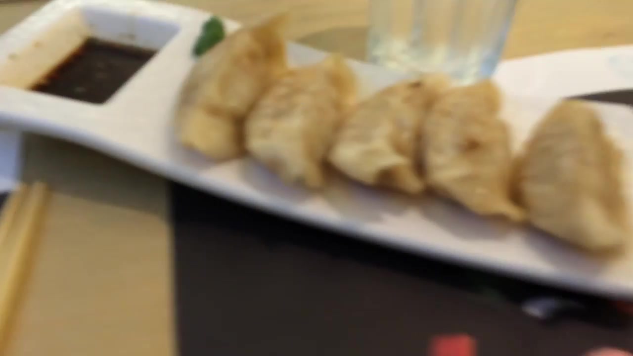 Plate of gyoza with dipping sauce at Wagamama Soho