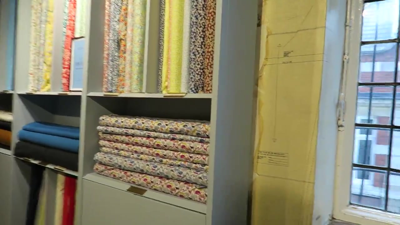 Floral fabric bolts and folded textiles in Liberty London's fabric department