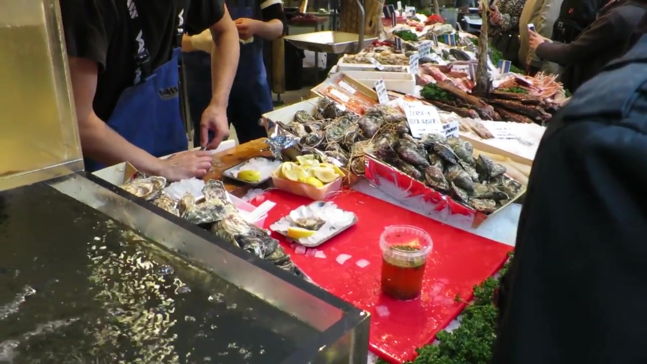 Oysters and seafood being prepared at a Borough Market counter