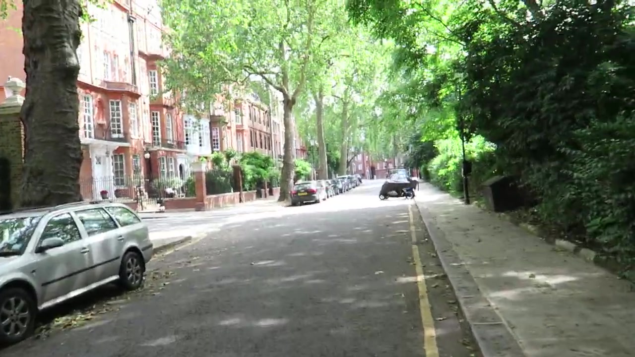 Quiet tree-lined Chelsea street with red-brick houses beside Cheyne Walk