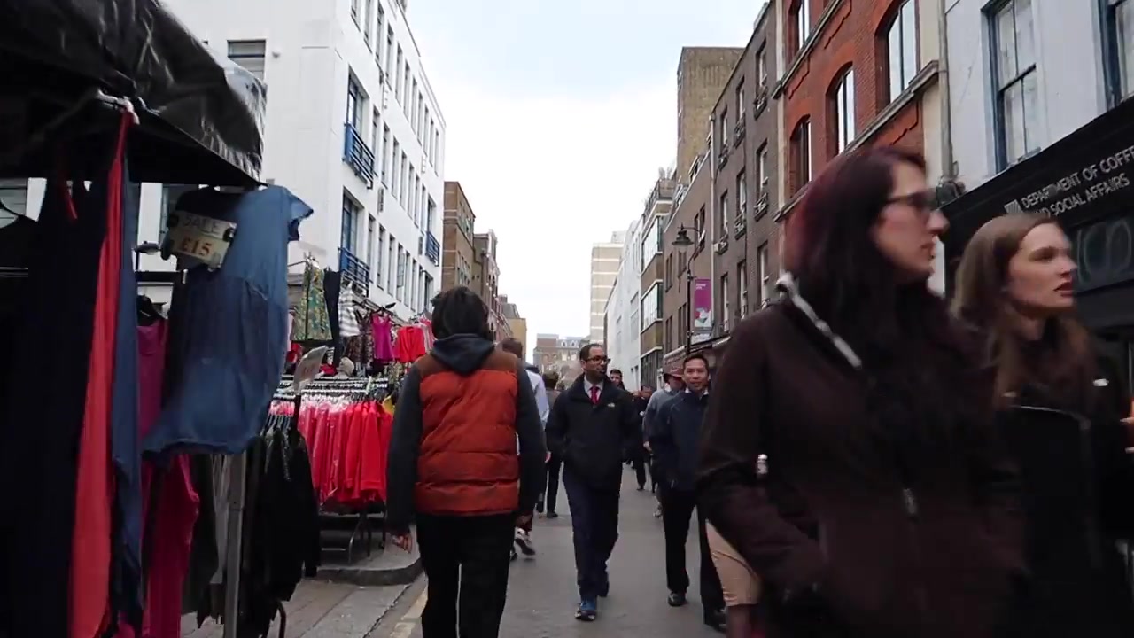 Clothing and general goods stalls lining Leather Lane Market in London