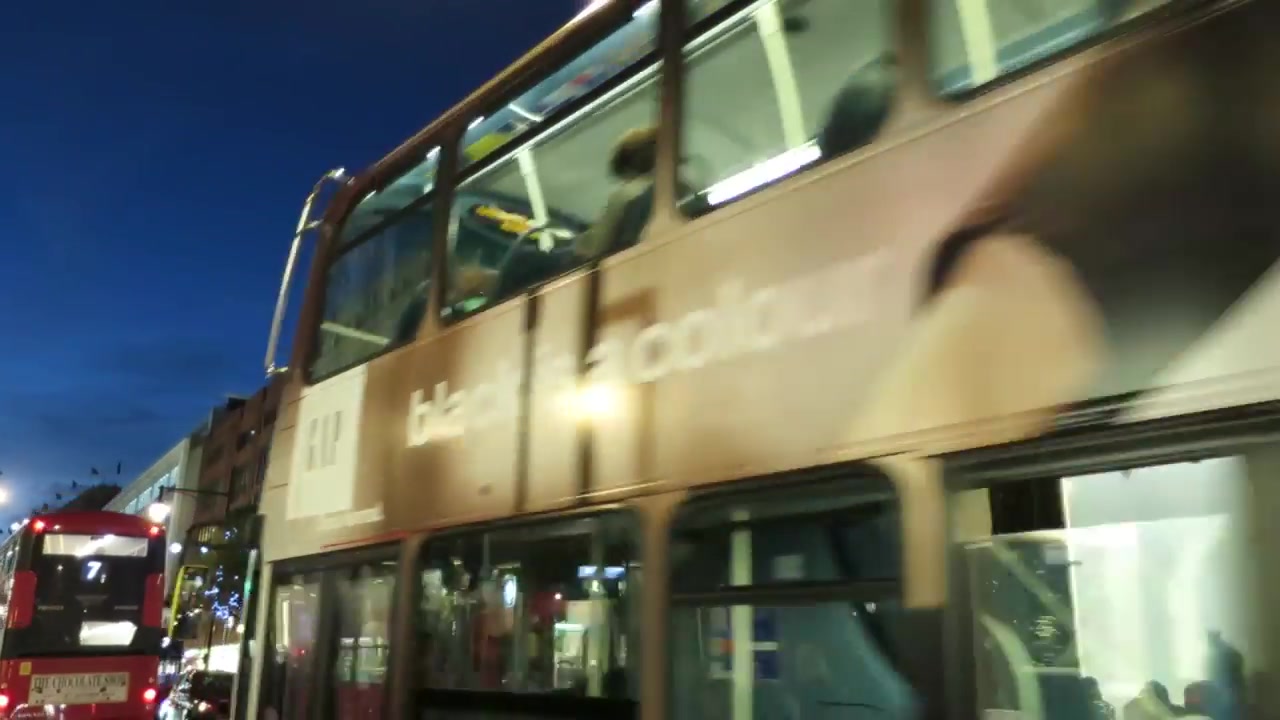 Marks and Spencer Oxford Street façade lit for Christmas with buses passing below.