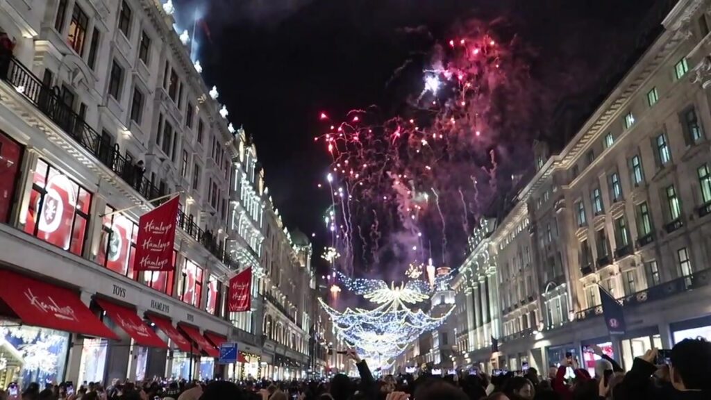 Red fireworks above the illuminated Spirit of Christmas angels on Regent Street