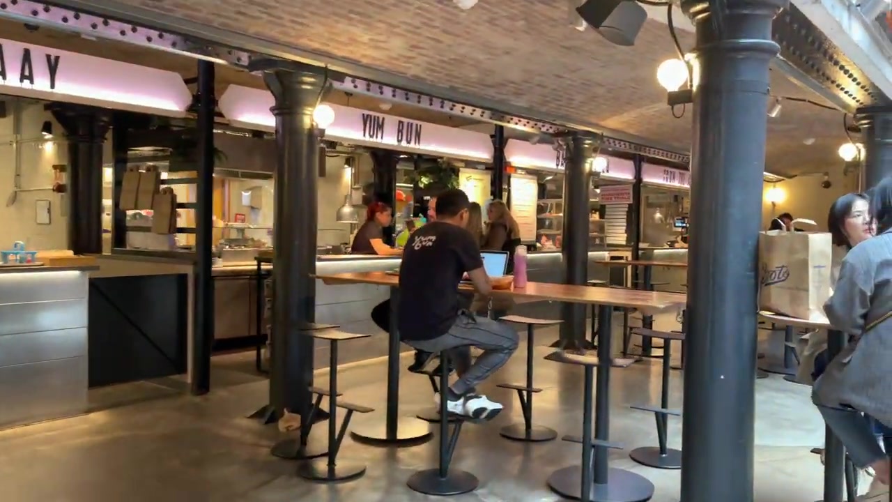 Yum Bun counter inside Seven Dials Market with illuminated signage and counter seating.