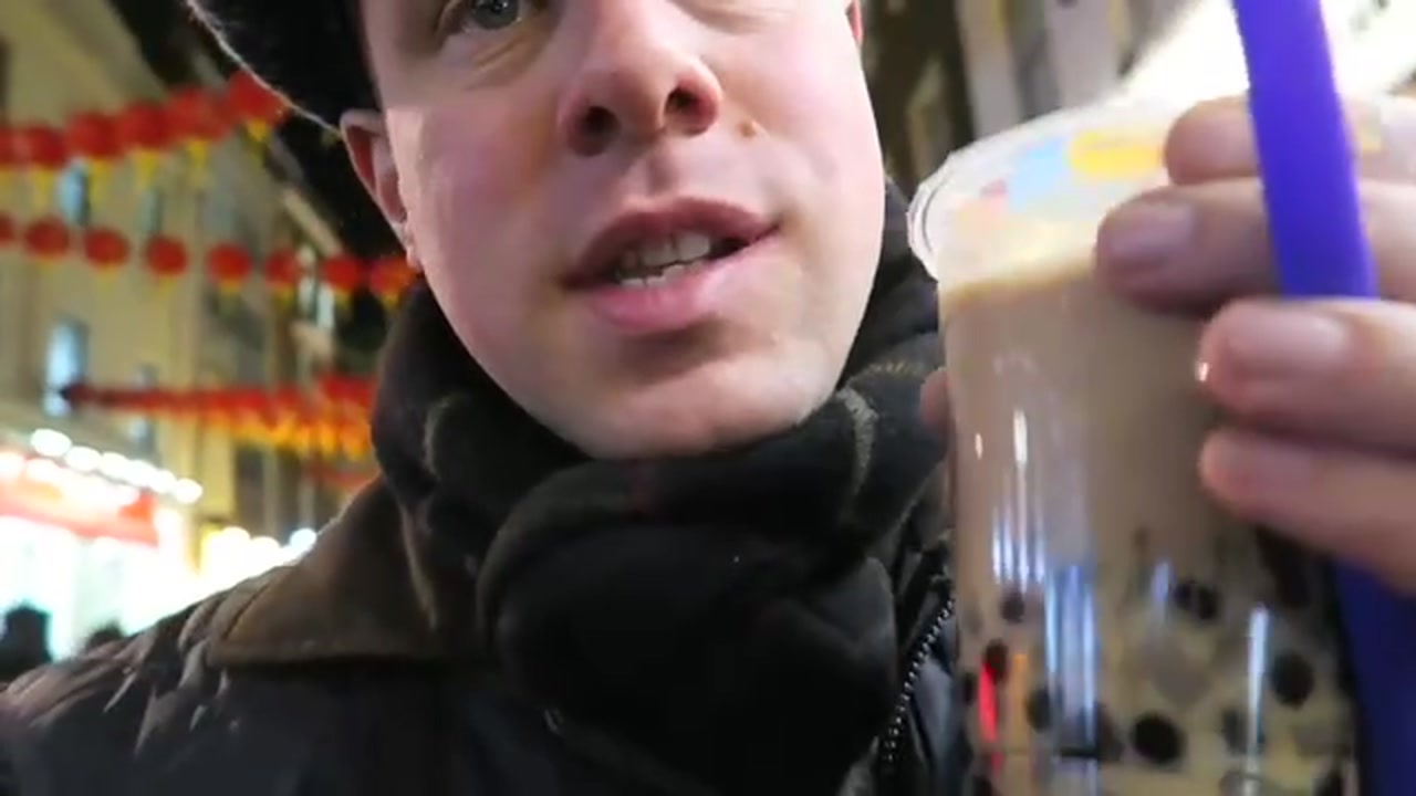 Barry Roberts holding bubble tea beneath red lanterns in London’s Chinatown