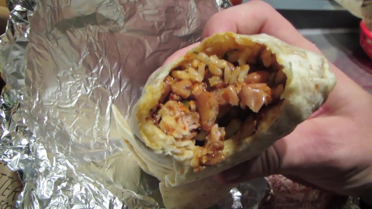 Open burrito showing rice, chicken, beans and salsa